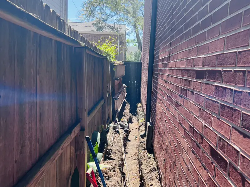 A run dug by hand down a three-foot side yard